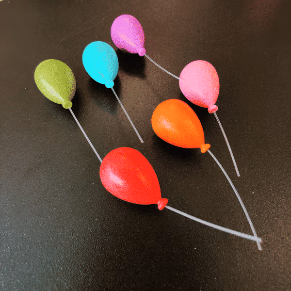 Koelkastmagneetjes Ballon in kleuren rood, oranje, roze, groen, aqua blauw en paars op een zwarte achtergrond