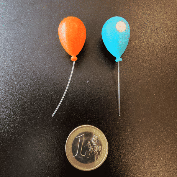 Twee koelkastmagneetjes in de vorm van opgeblazen ballonnen