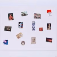 Een wit magneetbord met kaarten en foto's