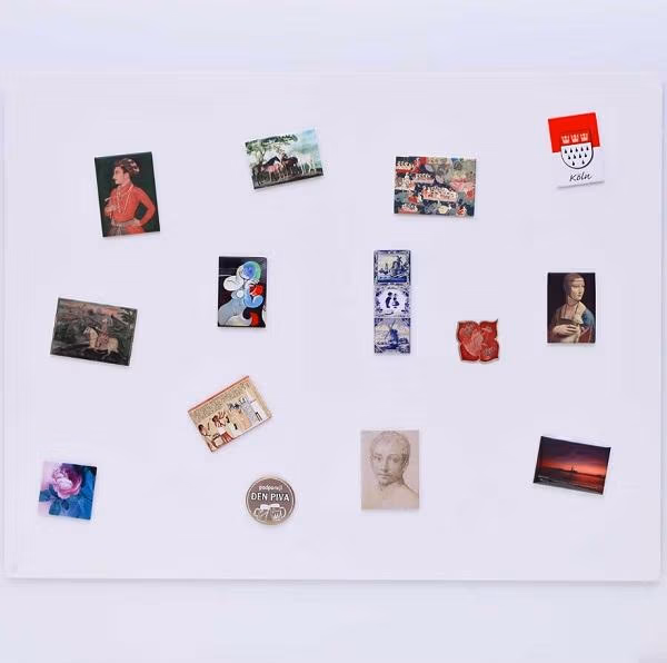 Een wit magneetbord met kaarten en foto's