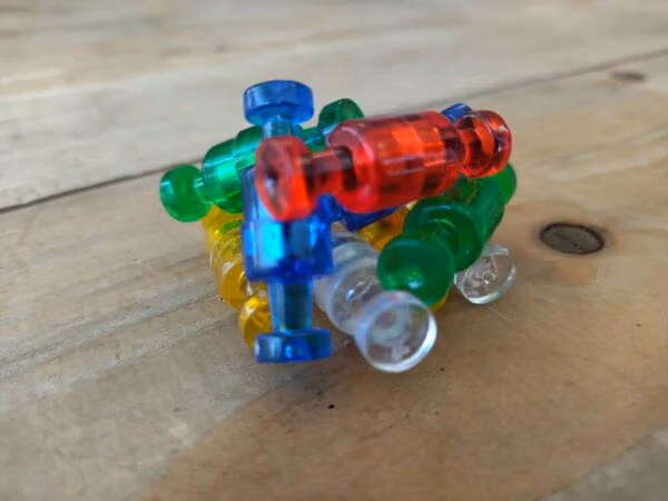 Diverse push pin vormige magneetjes in transparante kleuren die elkaar door de magneet aanraken