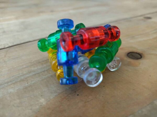 Diverse push pin vormige magneetjes in transparante kleuren die elkaar door de magneet aanraken