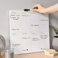 Voorbeeld van een ingevulde whiteboard weekplanner in het interieur van bijvoorbeeld een thuiskantoor