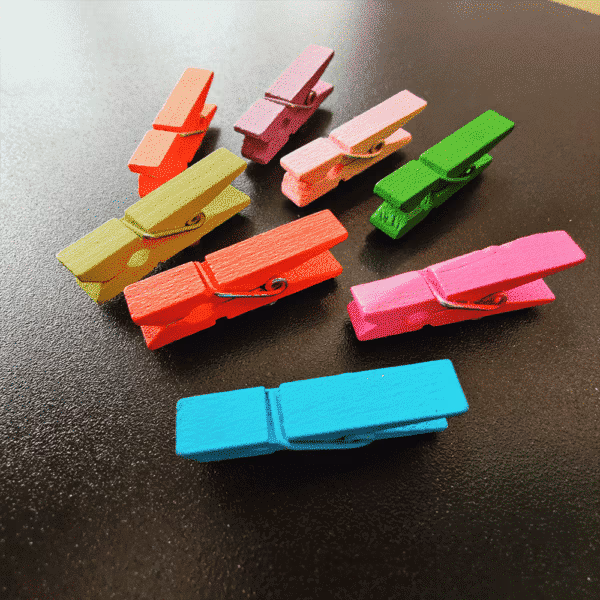 Magneet wasknijpertjes gekleurd op een zwart magneetbord