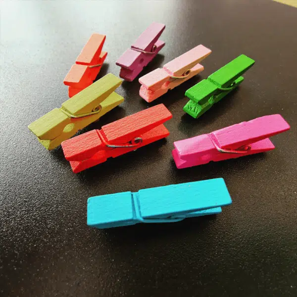 Magneet wasknijpertjes gekleurd op een zwart magneetbord