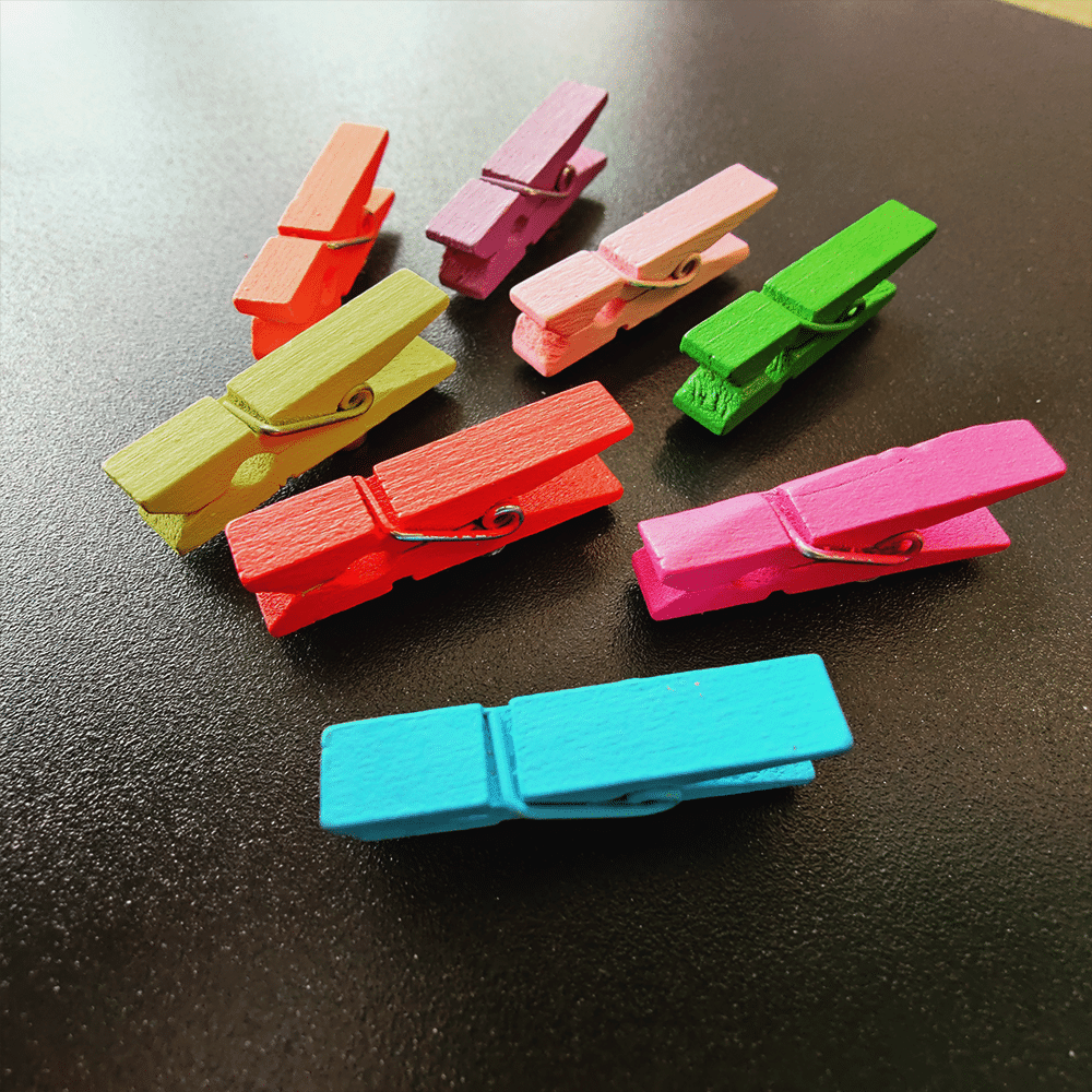 Magneet wasknijpertjes gekleurd op een zwart magneetbord