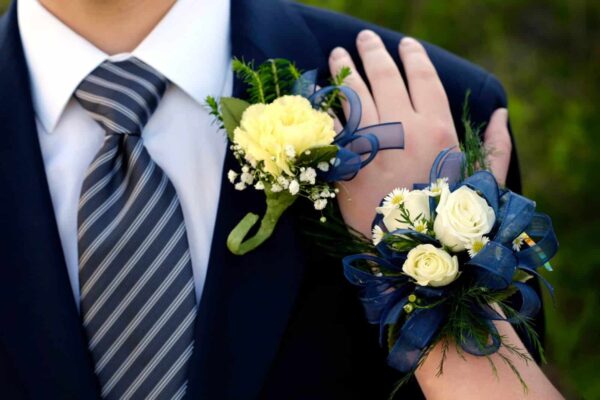 Corsage aanbrengen op pak van man met magneten