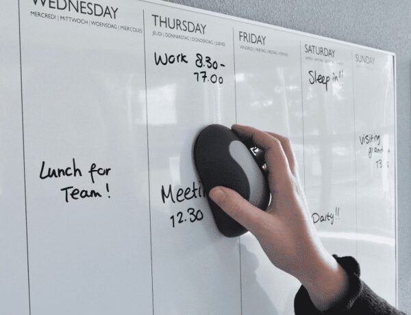 Een whiteboard wordt schoongeveegd met een magnetische whiteboardwisser