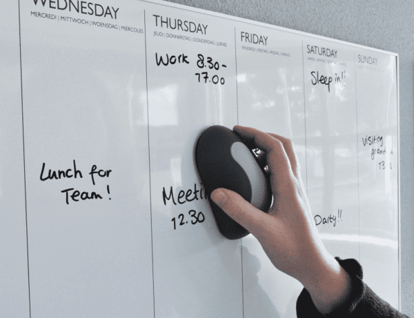 Een whiteboard wordt schoongeveegd met een magnetische whiteboardwisser