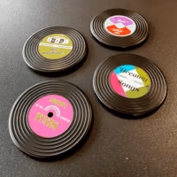 Vier verschillende koelkastmagneetjes in de vorm van retro grammofoonplaten