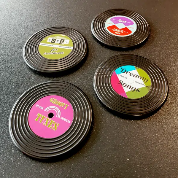 Vier verschillende koelkastmagneetjes in de vorm van retro grammofoonplaten