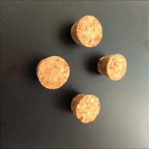 Kurkmagneetjes met sterke magneet 2 Vier sterke magneten in de vorm van een flessenkurk op een zwart magneetbord