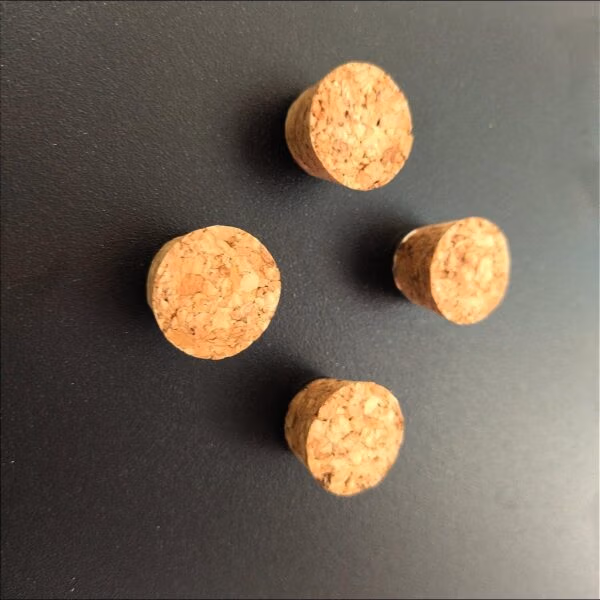 Vier sterke magneten in de vorm van een flessenkurk op een zwart magneetbord