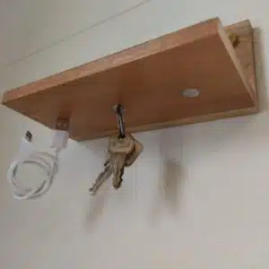 Sleutelhouder van hout - plankje met magneten 4 Houten plankje met drie magneten aan de onderzijde waar een sleutelbos en een telefoonkabel aan zin gehangen