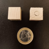 De onderzijde van de houten magneet waar het magneetje zichtbaar is.