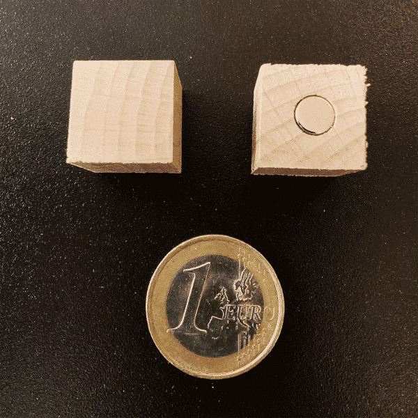 De onderzijde van de houten magneet waar het magneetje zichtbaar is.