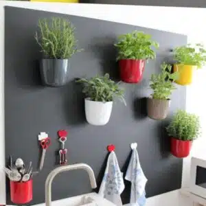 Magnetische ronde (planten) pot 15cm - meerdere kleuren 3 Zes magnetische plantenpotten met kruiden op zwart magneetbord in een keuken, verschillende vormen magnetische haken en een magnetische bakje voor bestek