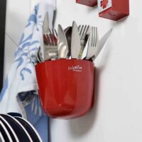 Magnetische ronde plantenpot van 10cm die aan een magneetbord hangt in de keuken met allerlei bestek erin opgeborgen