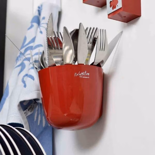 Magnetische ronde plantenpot van 10cm die aan een magneetbord hangt in de keuken met allerlei bestek erin opgeborgen