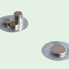 Twee dunne metalen plaatjes en met een aantal magneetjes die hierop blijven hechten