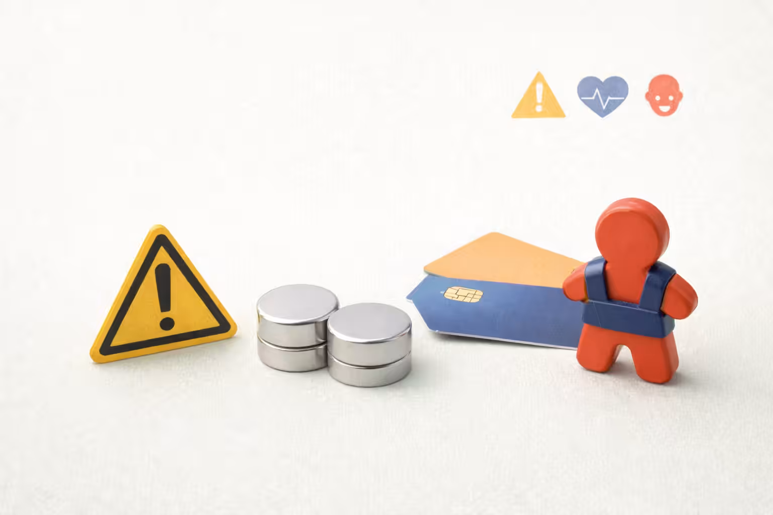 Magneten naast waarschuwingssymbool, bankpas en kindfiguur bij uitleg over veilig gebruik van magneten